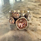 A silver statement ring featuring a large cushion-cut Swarovski crystal and three smaller round  clear stones.